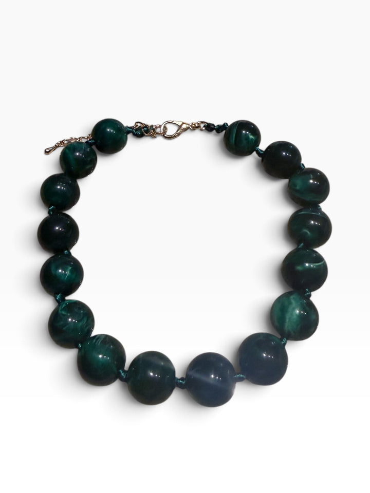 Marbled beaded necklace with large dark green and grey beads, dark cord, and silver-tone lobster clasp. Available in one size.