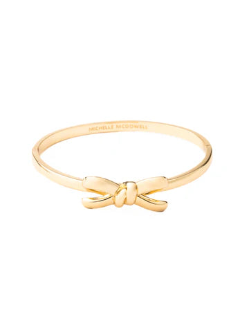 Delicate 18k gold plated bangle with a bow design at the front. Available in sizes S, M, and L. Smooth polished finish.