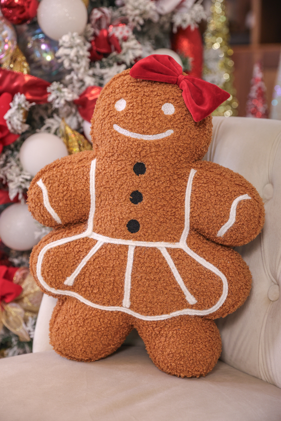 Gingerbread Girl Christmas pillow with red bow, white icing, and three black buttons.