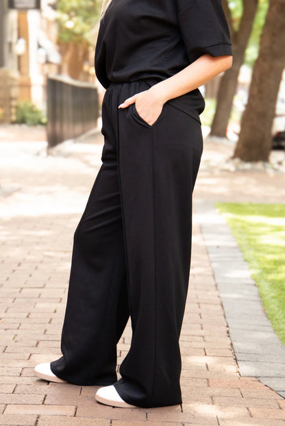 Black Butter Soft Pants with a loose fit and wide-leg silhouette. Available in sizes XS–XL.