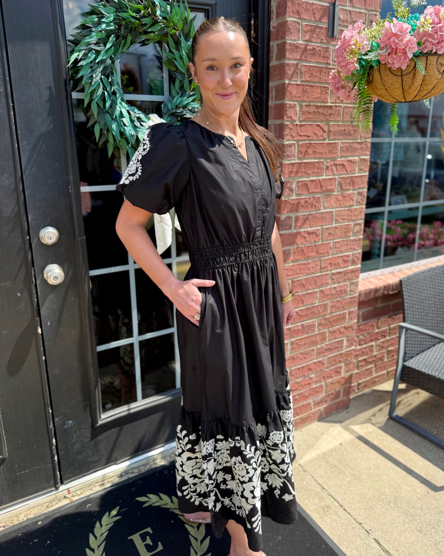 Tracey Aven Vines Black Dress with white floral embroidery and a smocked waist, available in sizes XS to XL.