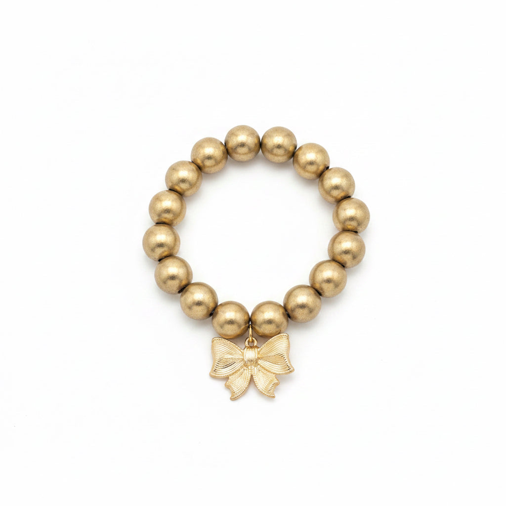 Gold beads and a central gold bow charm on an elastic band. Available sizes: S, M, L.