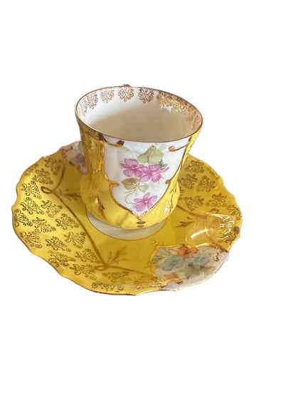 Antique hand-painted porcelain demitasse cup and saucer with gold patterns, pink floral designs. Size: demitasse only.