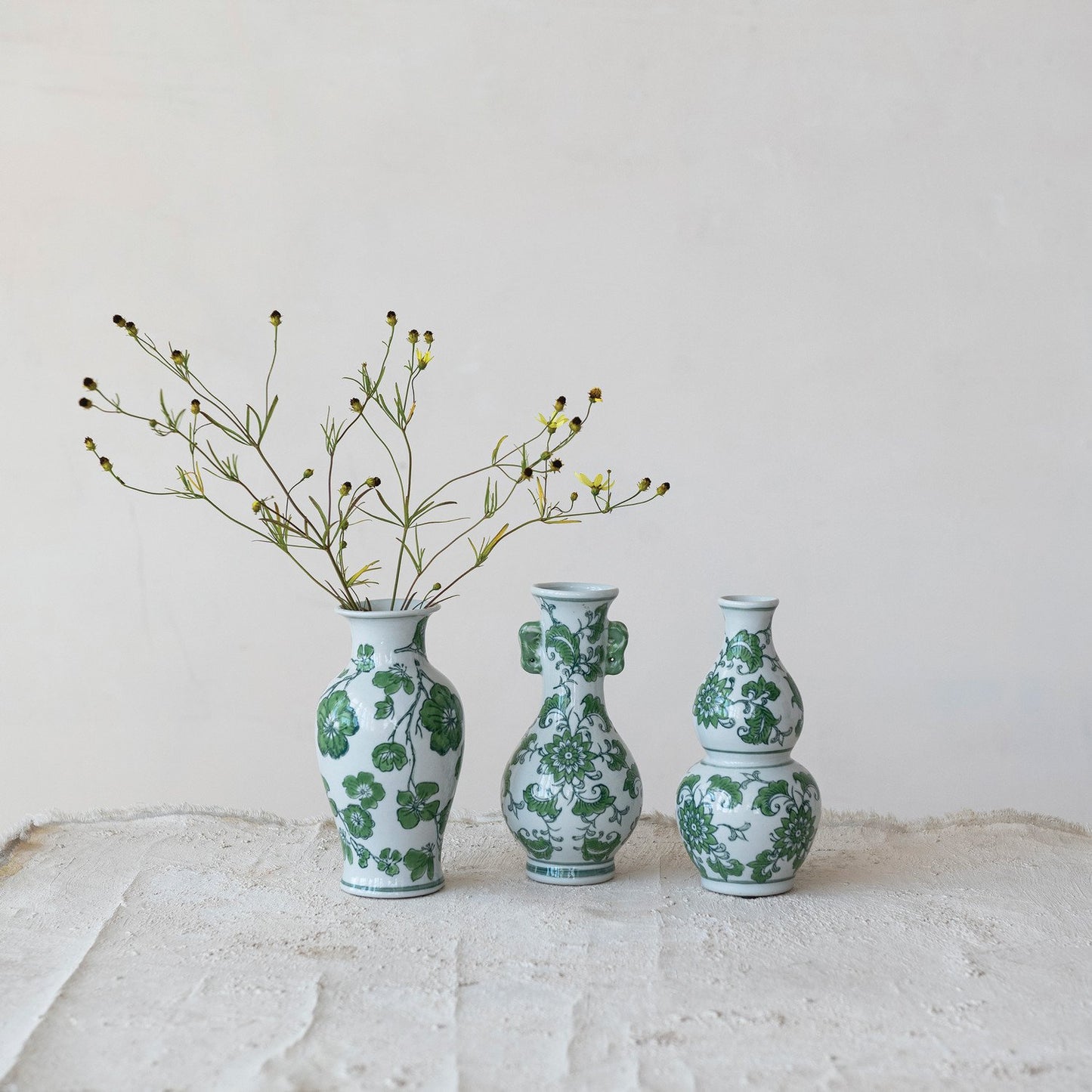 Hand painted green and white stoneware vases with floral designs. Available in small, medium, and large sizes.