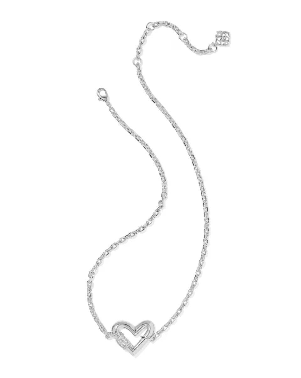 The Emery Heart Pendant Necklace by Kendra Scott: silver chain, heart-shaped white crystal, small charm near clasp. Sizes: 16", 18".