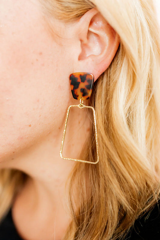 Kaelyn Earrings feature brown tortoiseshell triangles with large, dangling gold-plated geometric pendants. Suitable for sensitive ears. Available size: One size fits all.