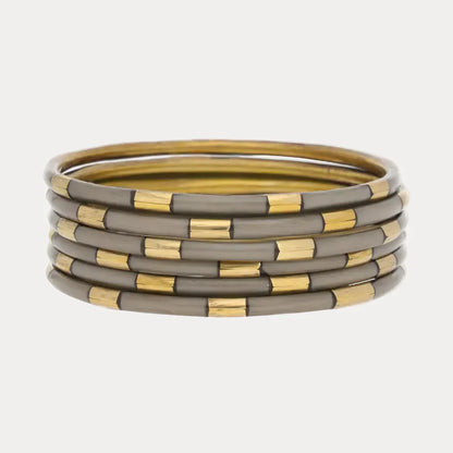 Five round bangles with alternating shiny gold and matte gray enamel accents. Available sizes: S, M, L.