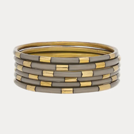Five round bangles with alternating shiny gold and matte gray enamel accents. Available sizes: S, M, L.