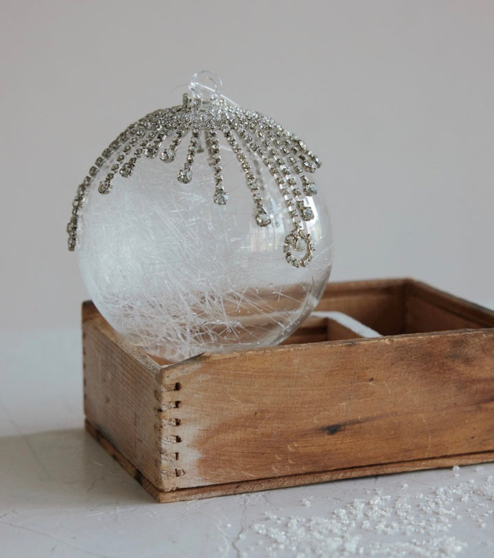 Frosted crystal icicle ornament with a frosted glass ball, white fiber filler, and hanging crystal icicle accents.