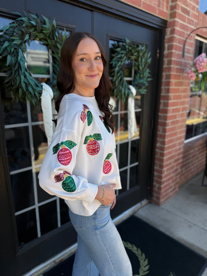 Millie Baubles &amp; Bows white long-sleeve holiday sweatshirt with sequined ornament and bow motifs.