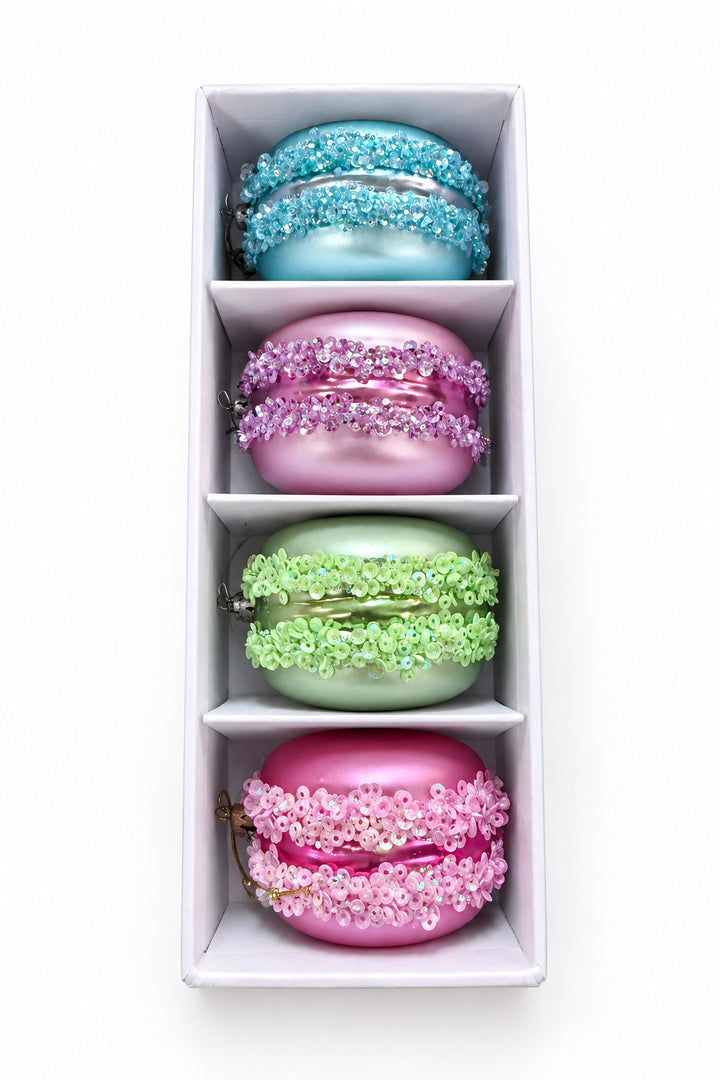 Set of four sequined macaron ornaments in light blue, purple, lime green, and pink, presented in a white gift box.