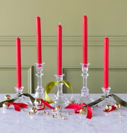 Five red taper candles in clear glass holders with moss ribbon and gold jingle bells.