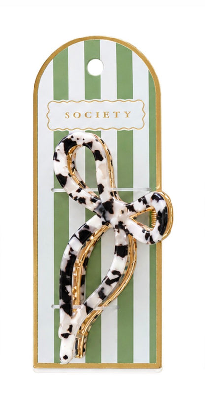 Black and white tortoise-shell patterned metal bow claw clip with a looped shape. Available sizes: small, medium, large.