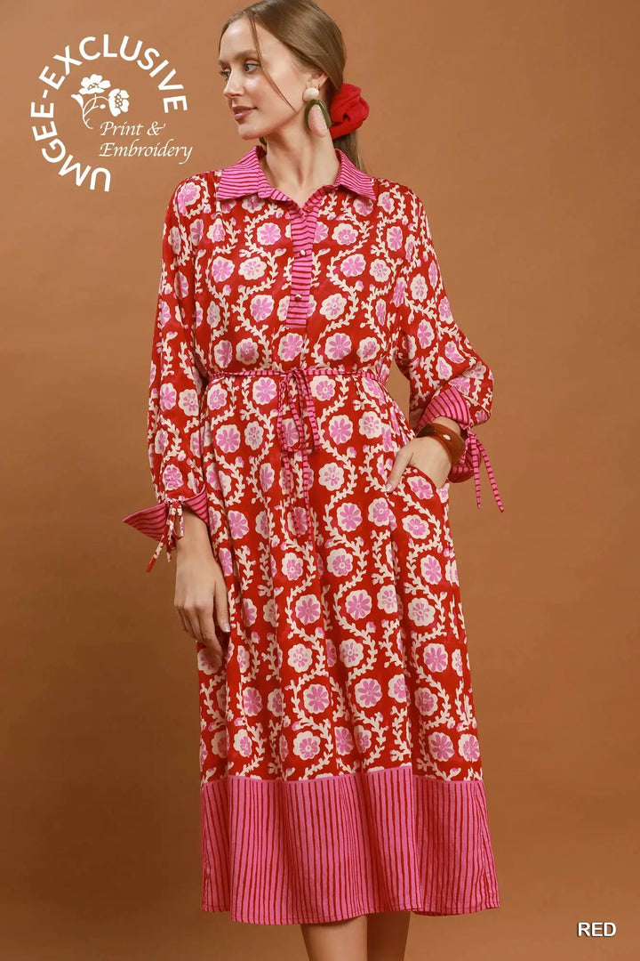 Mixed media print midi dress with collared neckline, long sleeves, tie cuffs, adjustable waist, and pink striped hem. Available in multiple sizes.