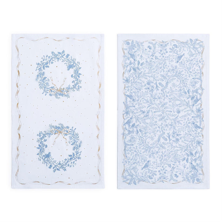 Two white Gilded Cottage Dish Towels with blue botanical patterns, featuring wreath and bird prints with gold accents.