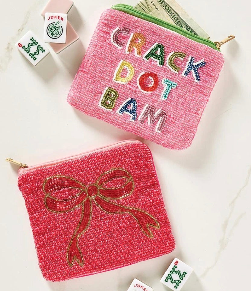 Two square Crack Dot Bam Beaded Pouches: one pink with “CRACK DOT BAM” in colorful letters, one pink with a gold-beaded bow.