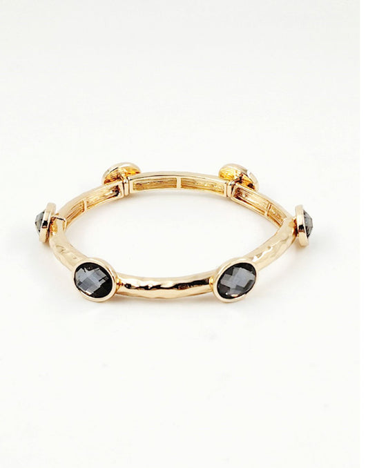 Gabby Black Diamond gold stretch bangle with four black faceted stones in bezel settings. Available sizes: S, M, L.