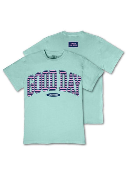 Light blue relaxed fit tee with bold striped "GOOD DAY" on front, "SIMPLY FOR GOOD" at back collar. Sizes: S-XL.