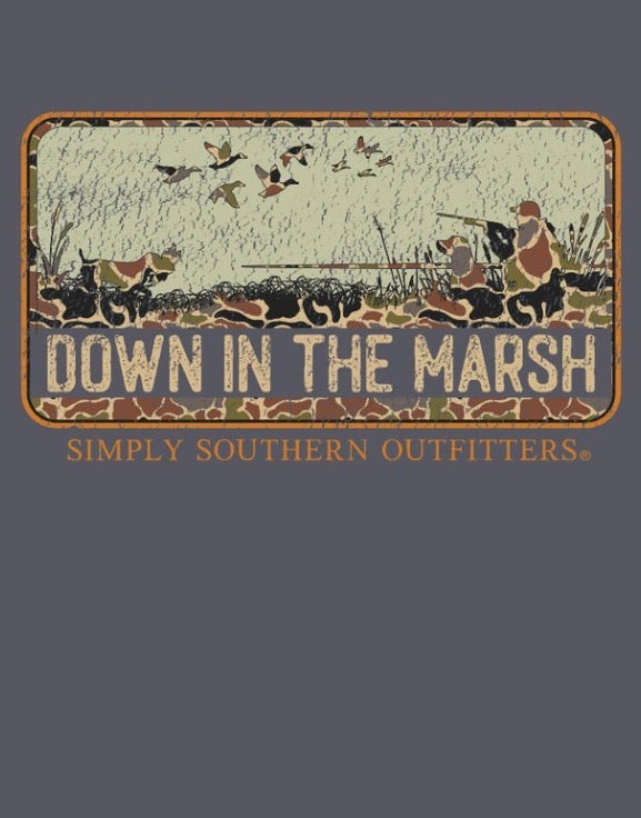 The Down In The Marsh Graphic Tee features a rustic “DOWN IN THE MARSH” sign with silhouettes of hunters, dogs, and flying ducks; bold orange “SIMPLY SOUTHERN OUTFITTERS” lettering sits below the scene on a dark background. Available in sizes S–XXL.