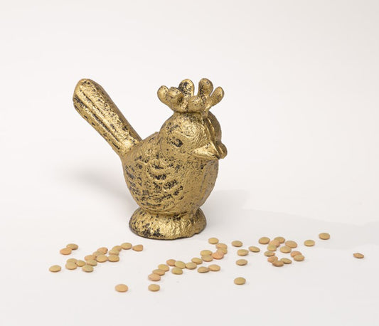 This is a golden sculpture symbolizing a 4-inch Iron Bird with Crown. Its distinguishing features include a raised tail and an open beak. The product does not come with any additional items such as scattered lentils shown in the image. It only stands alone on any surface, preferably white for visual emphasis. The size available for this product is 4 inches.