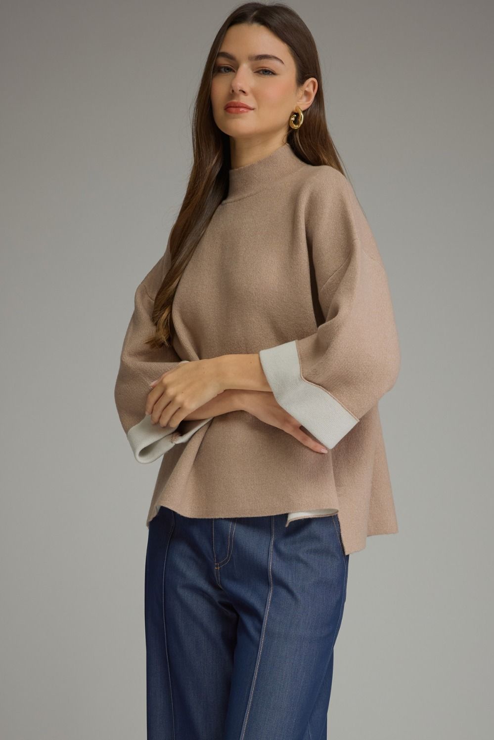Tan contrast mock neck sweater with wide three-quarter sleeves and cream cuffs. Available in sizes S-XL.