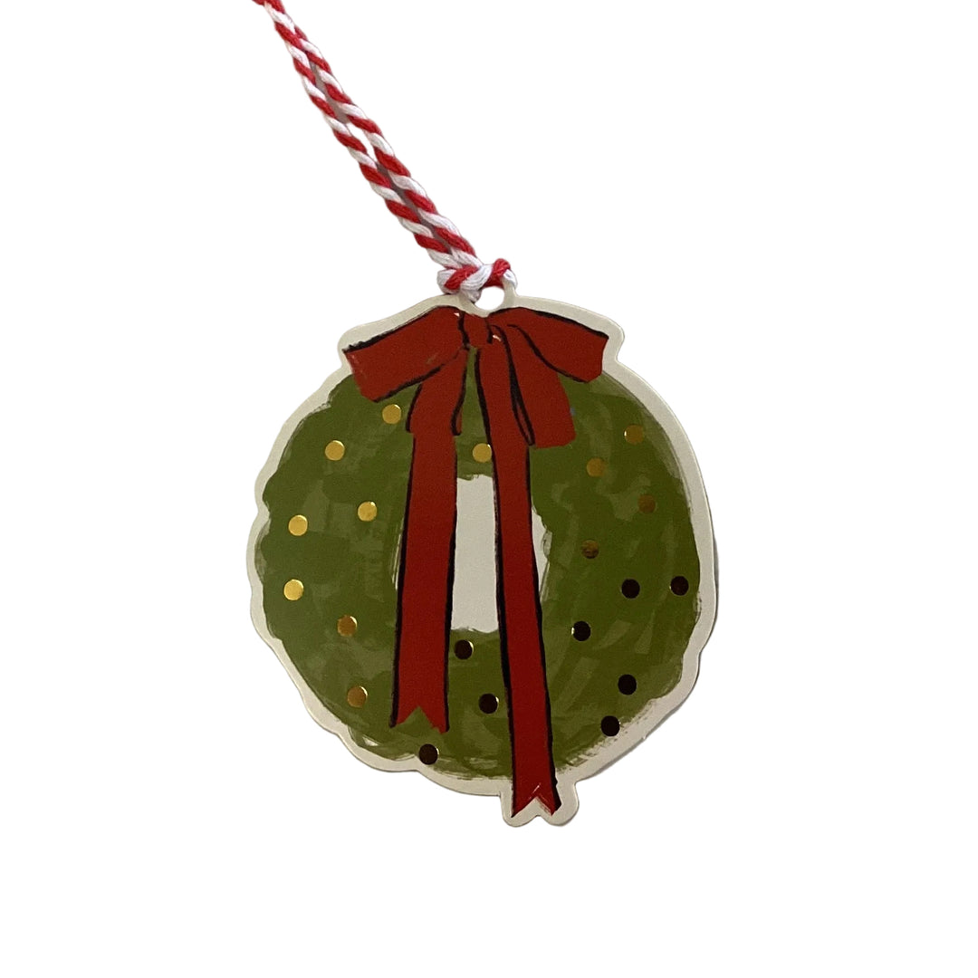 Holiday wreath gift tag with red ribbon and gold accents.