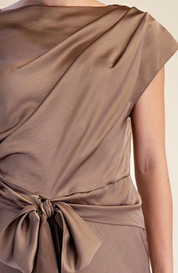 Asymmetrical Tie Midi Dress in taupe with draped fabric, waist bow, and one cap sleeve; available in sizes XS-XL.