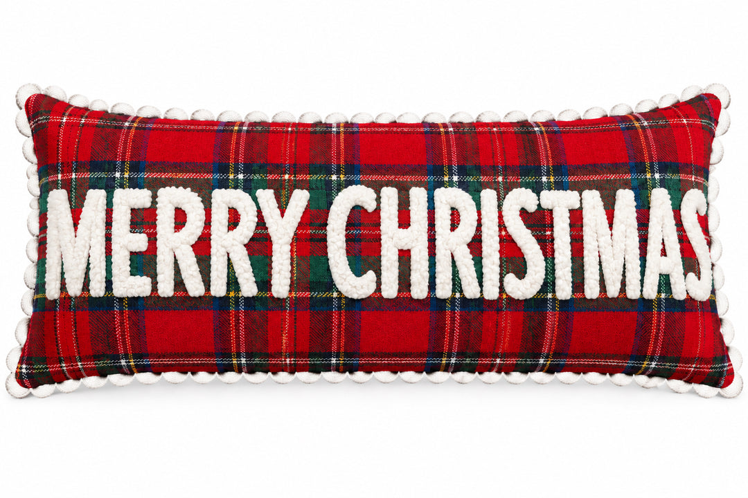 Merry Christmas Plaid Lumbar Pillow: rectangular red, green, and blue plaid pillow with white pom-pom trim and “MERRY CHRISTMAS” appliquéd letters.