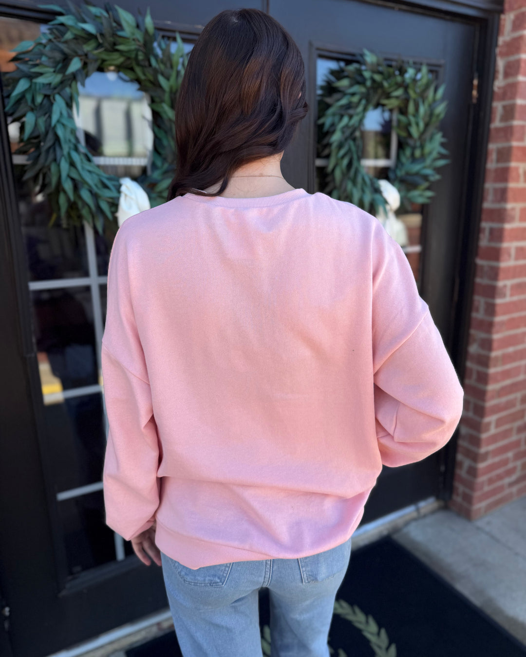 Light pink Clara Wreath Sequin Sweatshirt with a crewneck and sequin wreath design. Available in multiple sizes.