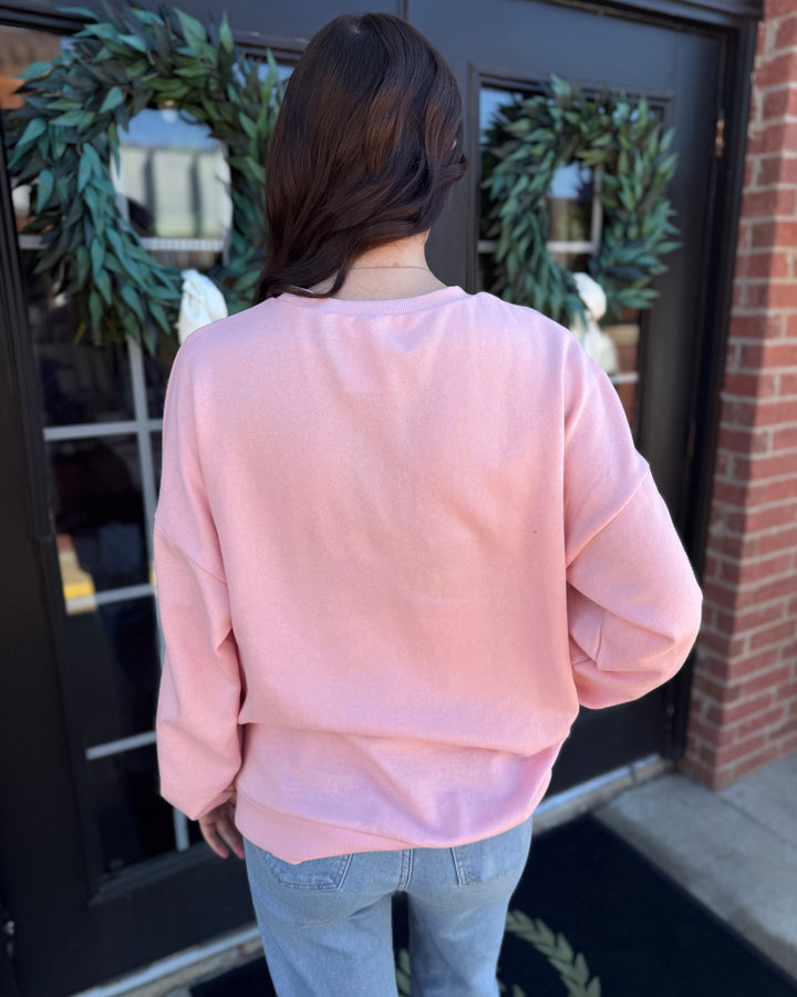 Light pink Clara Wreath Sequin Sweatshirt with a crewneck and sequin wreath design. Available in multiple sizes.
