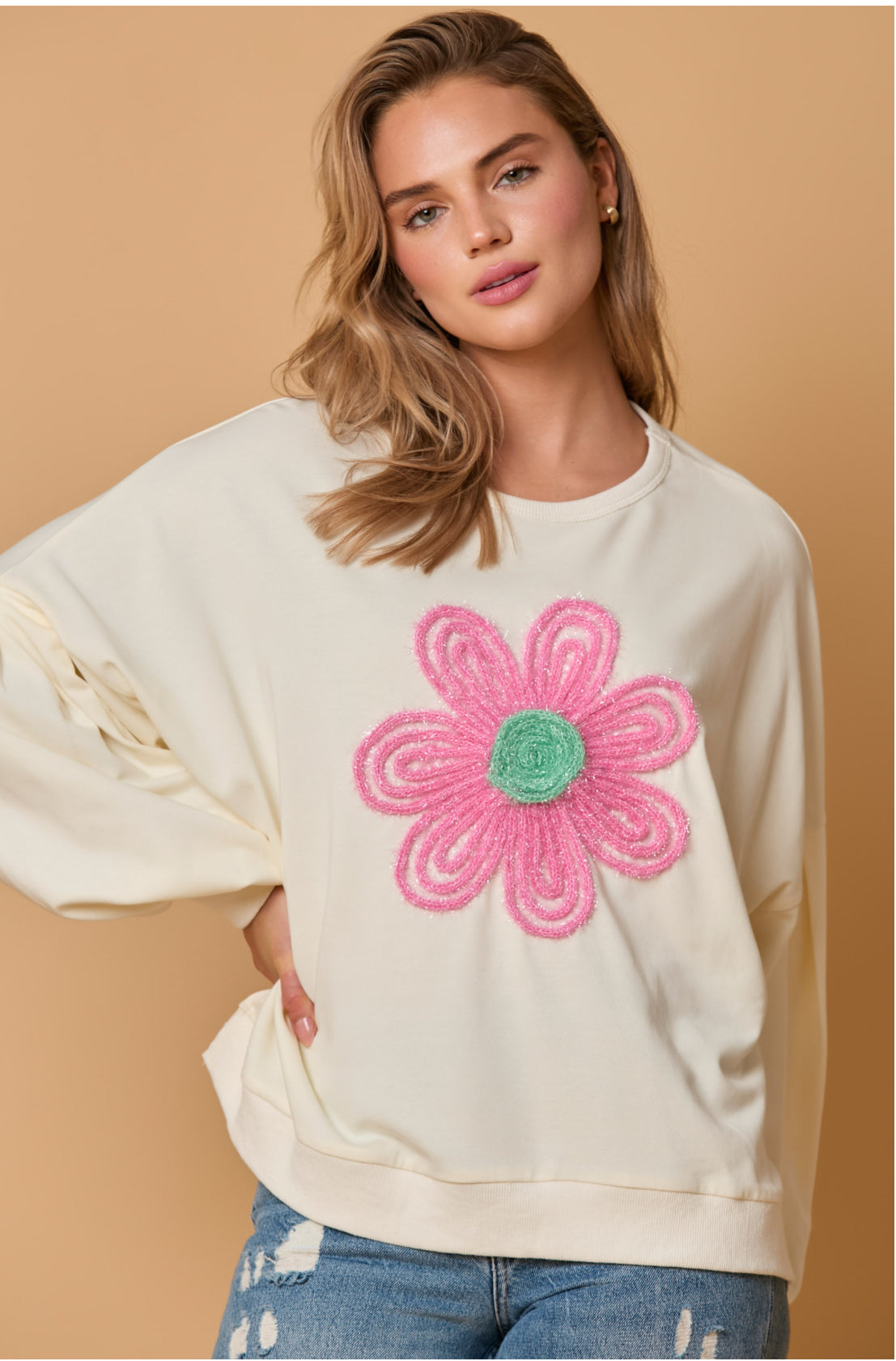 Cream Round Neck Sweatshirt with Flower Applique. Available in sizes: S, M, L, XL.