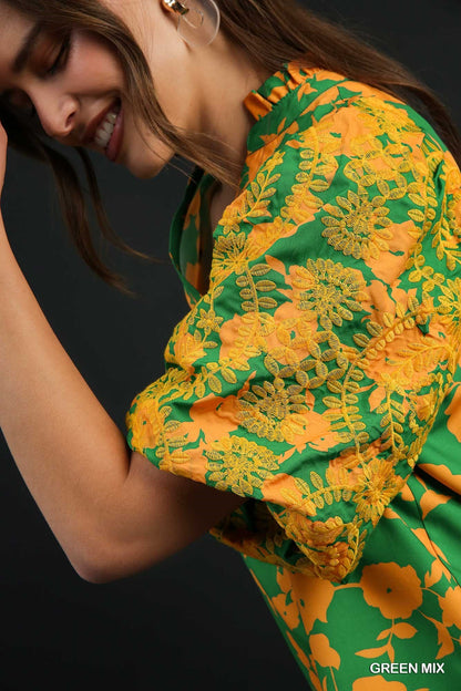 Bright green and orange floral dress with split neck and embroidered puff sleeves. Available in sizes XS to XL.