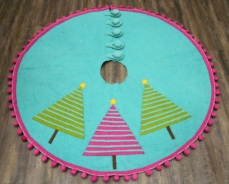 Round turquoise wool tree skirt with pink pom-pom trim, three striped Christmas tree appliqués with yellow star toppers, and a button-loop closure.