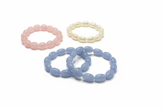 Oval Stone Stretch Bracelets in pink, white, and light blue pastel hues; available in S/M and M/L sizes.