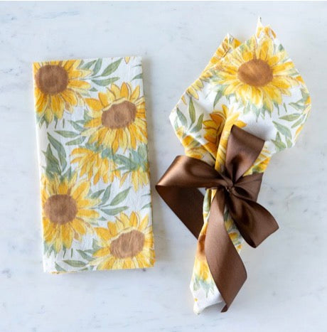 Sunflower-patterned napkins available in multiple sizes, shown folded and tied with a ribbon.
