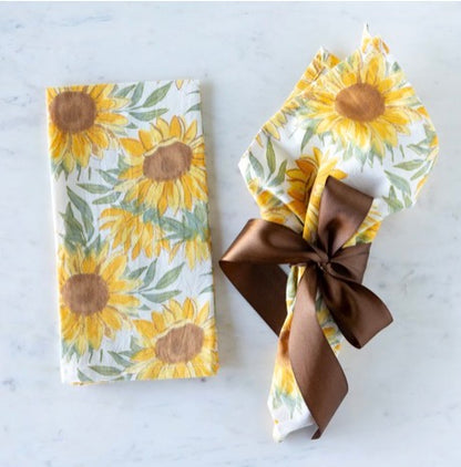 Sunflower-patterned napkins available in multiple sizes, shown folded and tied with a ribbon.