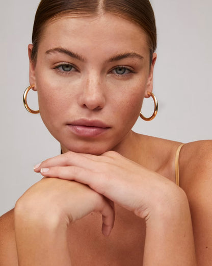 Colette Large Gold Hoop by Kendra Scott shown; available in large and other sizes. Simple, elegant gold hoop earring design.