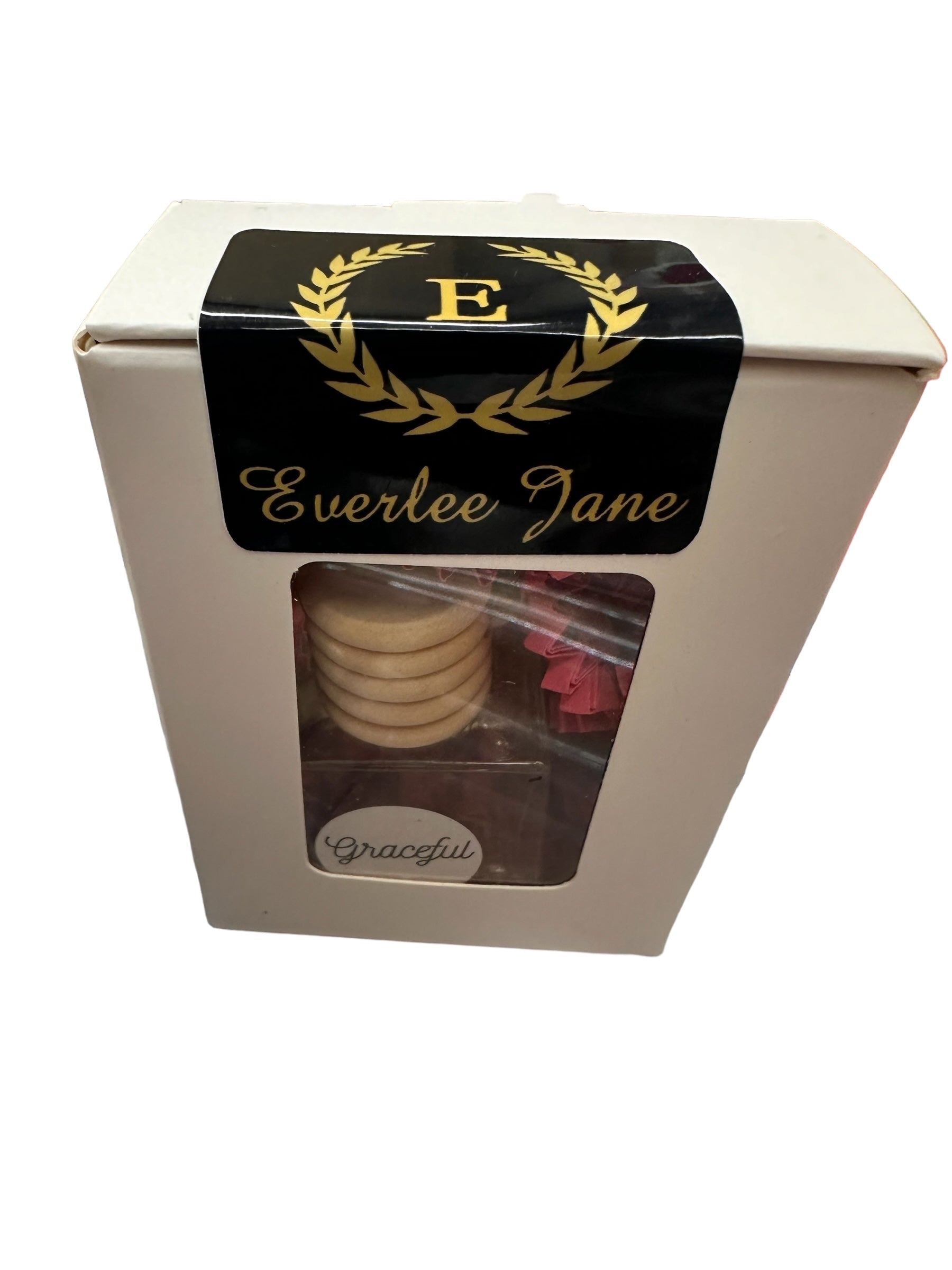 A white box with a black and gold label displaying the name "Everlee Jane" and a decorative letter "E" at the top with laurel branches. The box has a clear window showing stacked circular cookies inside. The word "Car Diffusers" is printed on the bottom inside the window, reminiscent of car diffusers for a peaceful drive. Sizes available: N/A.
