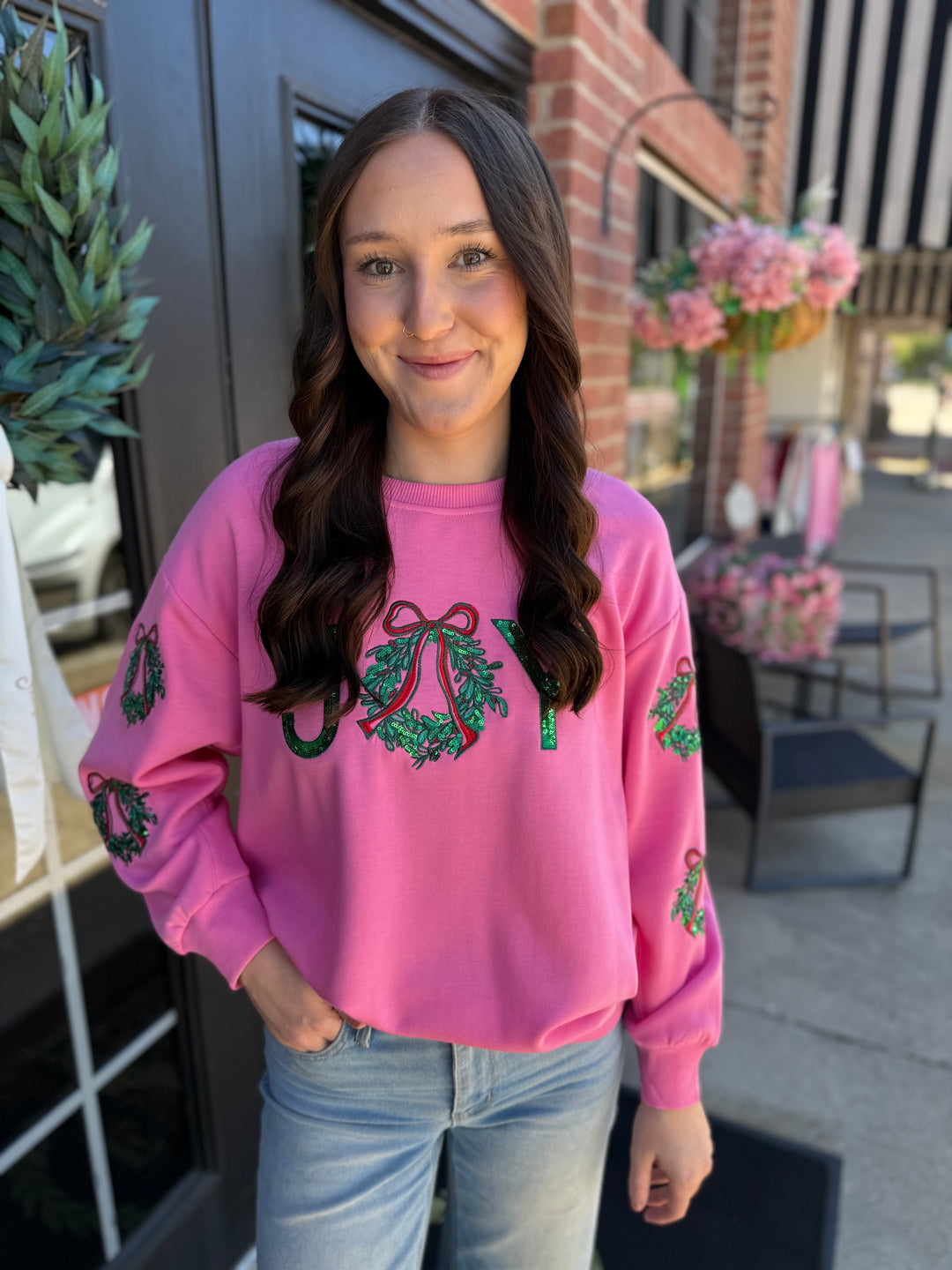 Pink Sarah Joy Wreath Sweatshirt with sequined “JOY” wreath chest graphic and sleeve accents. Available in multiple sizes.