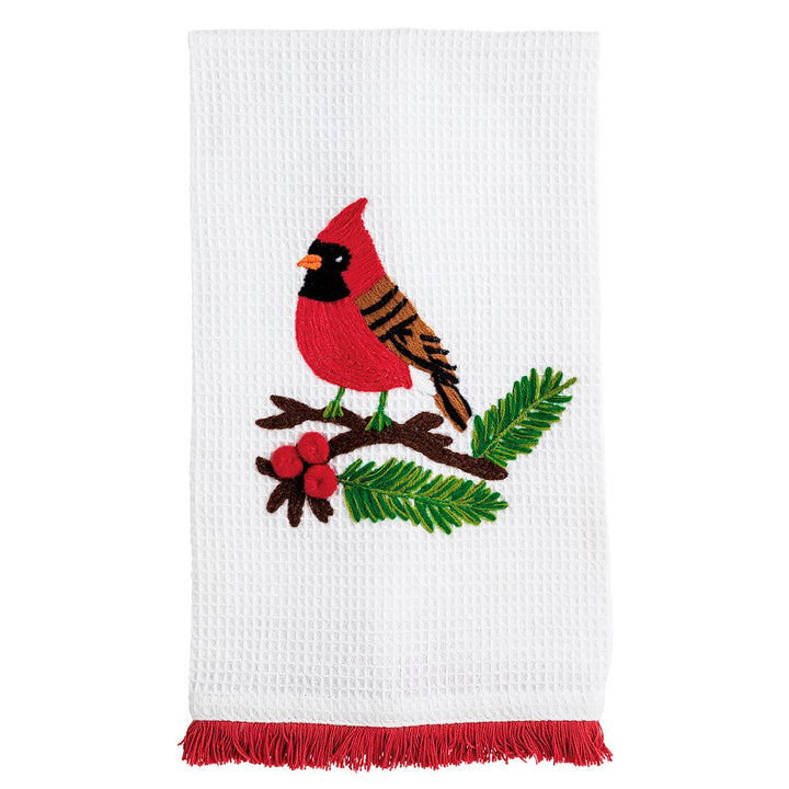 White waffle knit Christmas hand towel featuring an embroidered cardinal on a pine branch with red berries and red fringe trim.