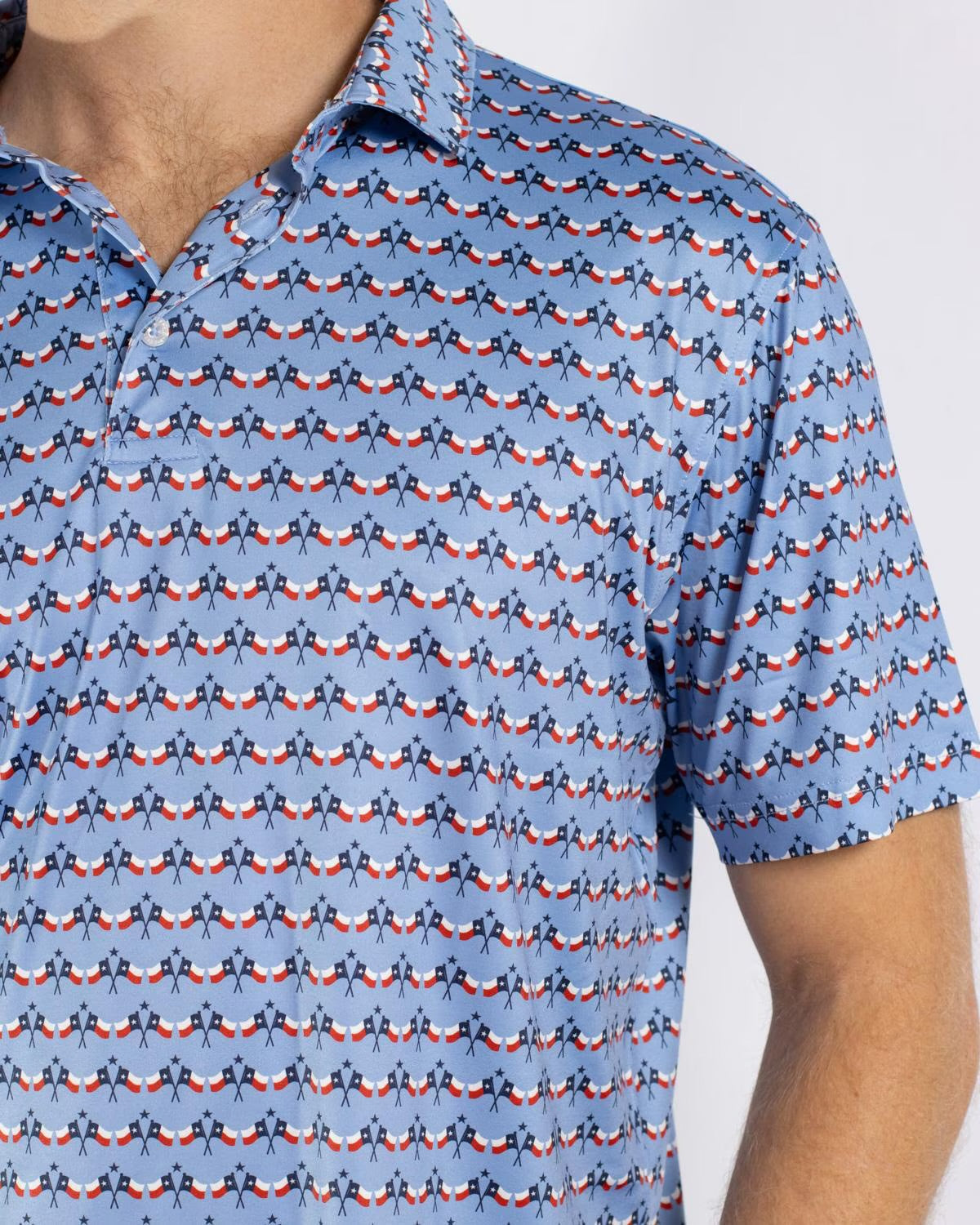 Short-sleeve Men’s Texas Flag Performance Polo in light blue with a repeating pattern of small red, white, and dark blue birds. Available in sizes S-XXL.