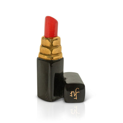 Ceramic Nora Fleming Minis figurine shaped like red lipstick in black and gold tube, cap off with gold monogram. Size: Mini.