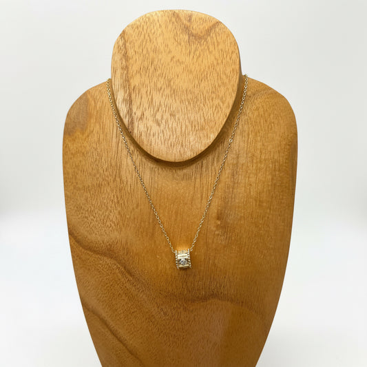 The Ezra Gold Pendant Necklace features a small cylindrical pendant with subtle crystal accents. Available in 16, 18, and 20 inch lengths.