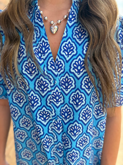 Bright blue midi dress with white and navy print, button-down front. Available in sizes XS-XL.