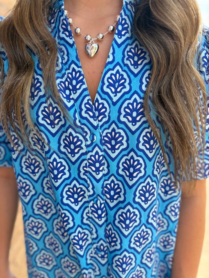 Bright blue midi dress with white and navy print, button-down front. Available in sizes XS-XL.