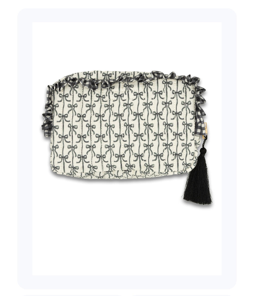 Rectangular white clutch with black bow pattern, ruffled top trim, black tassel accent. Sizes: Small, Medium, Large.