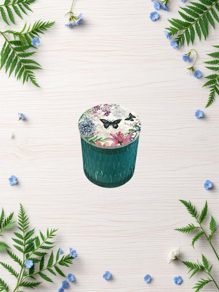 Buttercream Vanilla Medium Tumbler Candle in teal glass jar with floral butterfly lid. Burn time: up to 35 hours. Medium size only.
