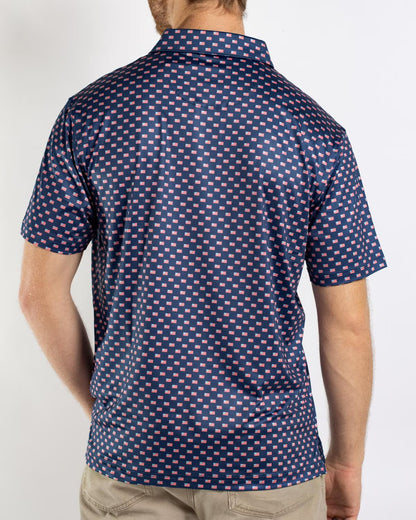 Men’s Americana Performance Polo in navy blue with pink and white square pattern and short sleeves; available in sizes S-XXL.