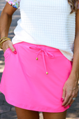 Solid Neon Pink Skort with drawstring waist, front pocket. Available in sizes XS-XL.