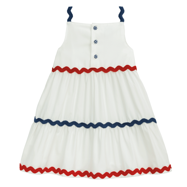 White sleeveless dress with blue straps, chest buttons, and red and blue zigzag trim. Available in sizes 2T-6.